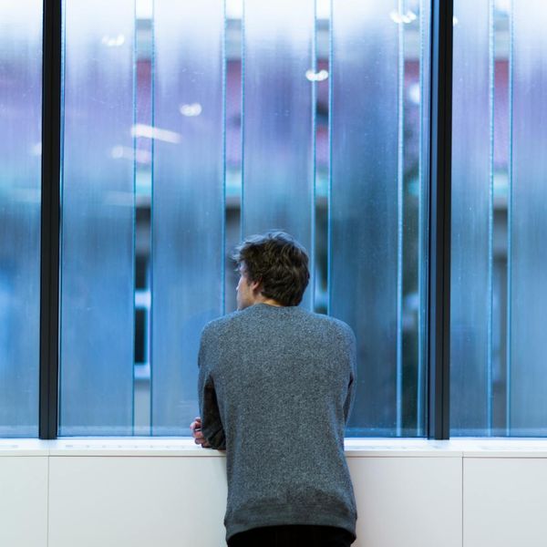 Person finding balance and focus in a minimalist environment with blue light.
